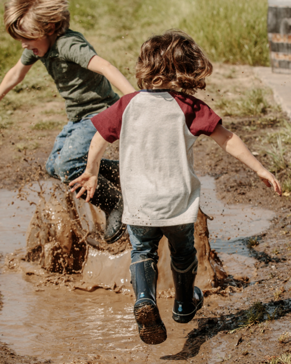 Click to shop kids lightweight styles featuring kids jumping in a mud puddle.