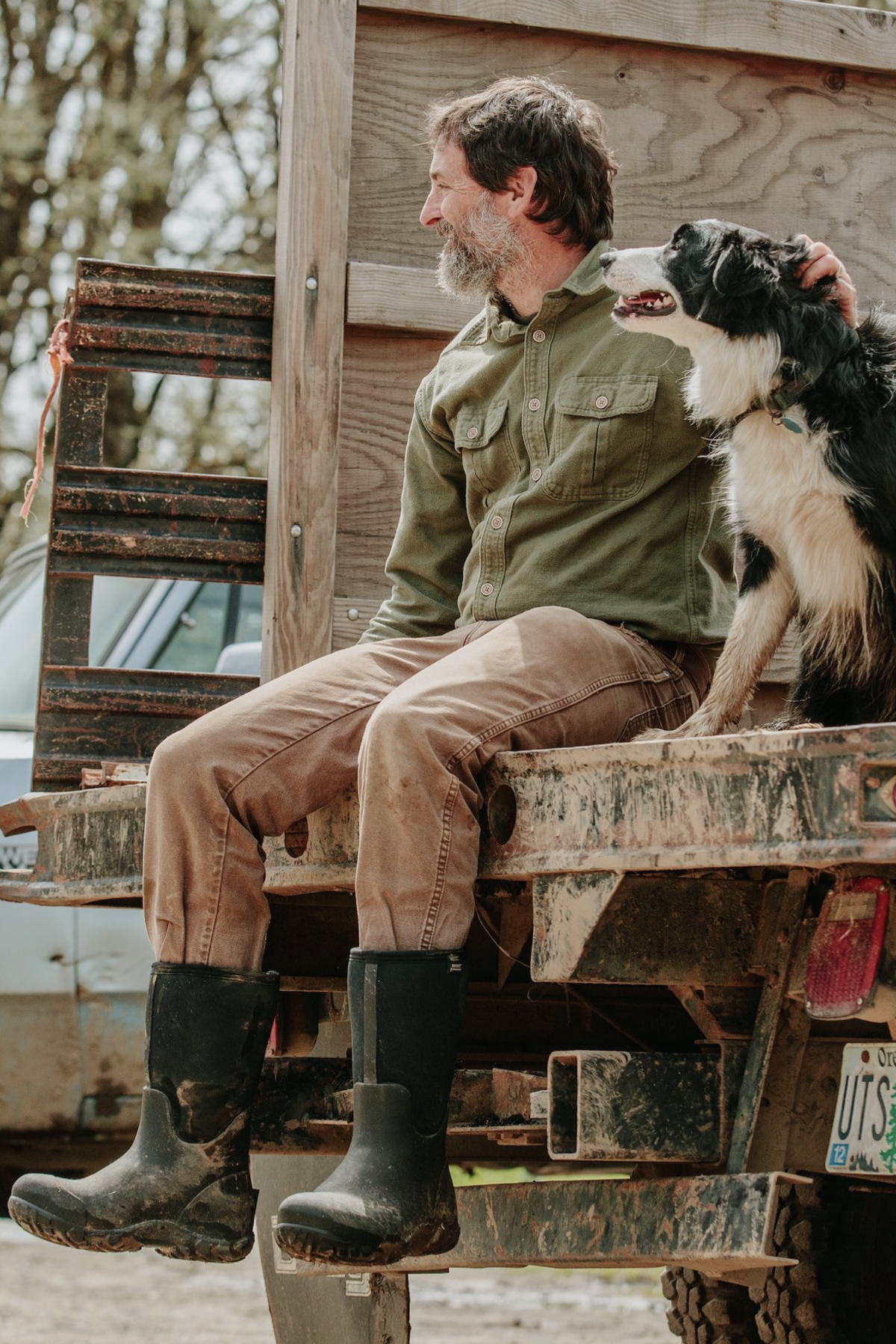 Shop our newest markdowns, now 25% off.  The image shown is a man and his dog sitting on the back of a truckbed.