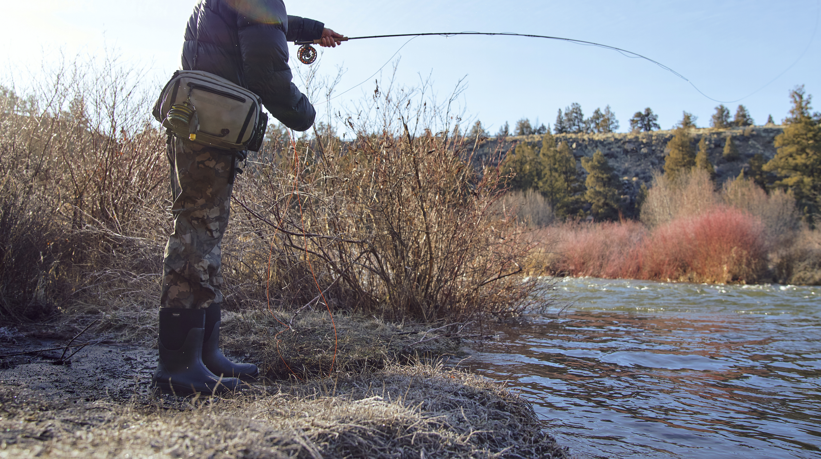 A man fly fishing.  Shop our Men’s Classic seamless boots in black. 