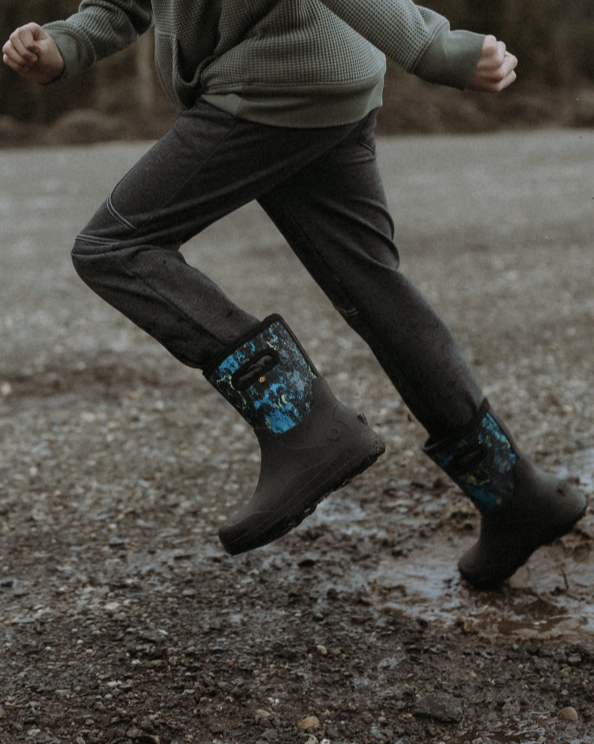 A waist shot image of a kid splashing through a puddle wearing our new York seamless.