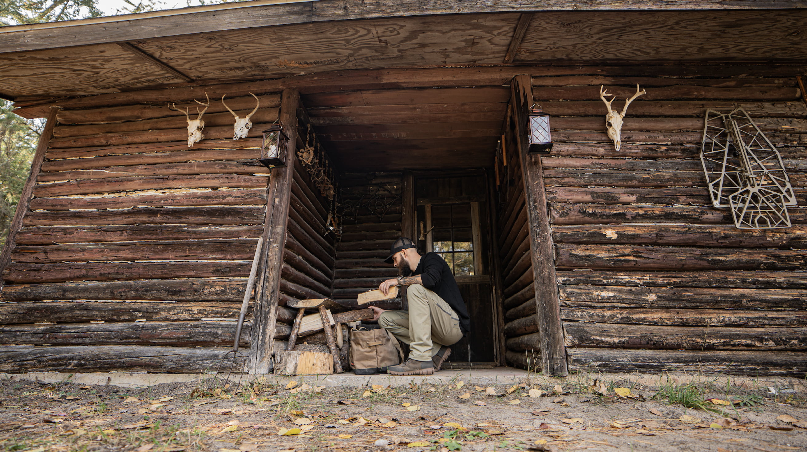 A man picking up wood at his cabin. Shop our Men's Arcata Urban leather lace boots.