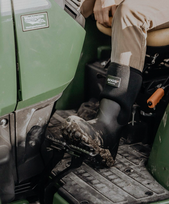 A close up shot of our Men's workman boots on a green tractor