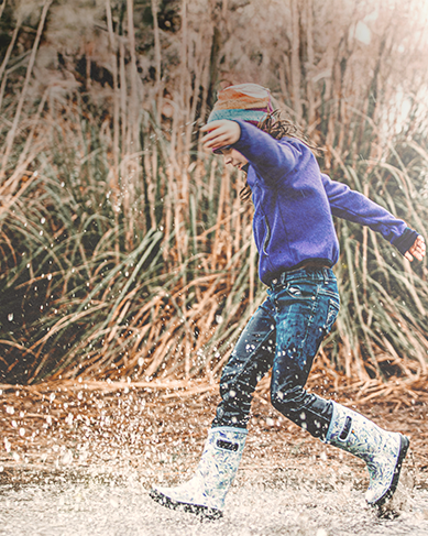 Shop our mid-season sale featuring a girl playing in the rain in rainboots.