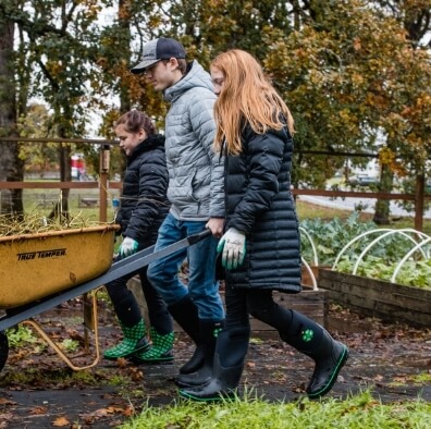 Our Featured Partners. Click here to learn more about kids outdoor education programs that provides experiences where youth learn by doing. The picture shown a three kids pushing a wheel barrel in the garden.