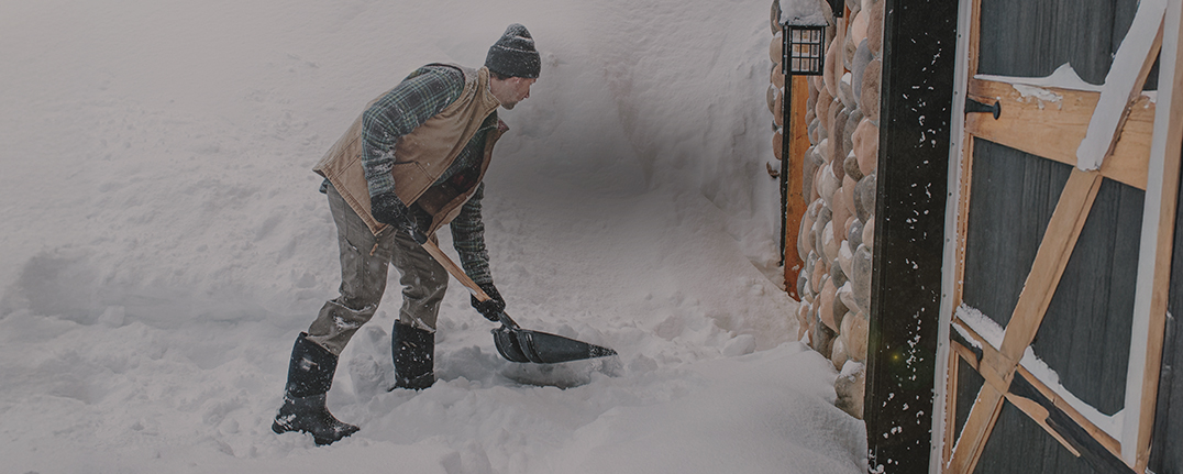 Shop men's winter boots featuring a man shoveling snow.