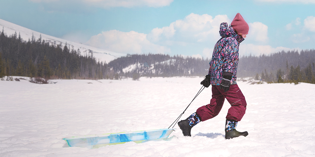 Shop the Kids' York Seamless featuring a child pulling a sled in the snow.