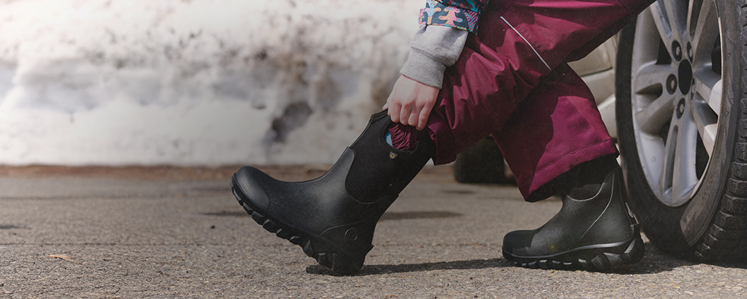Shop kids' Classic Seamless featuring a kid putting on their boots in the parking lot.