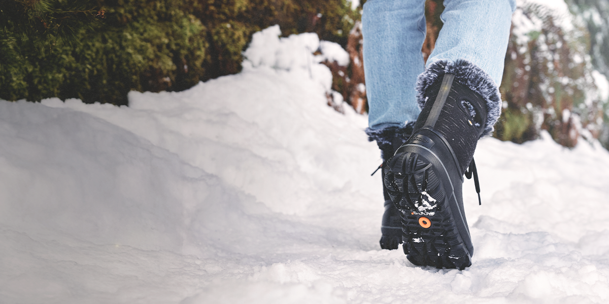 Shop Bogs Women's winter boots featuring the Arcata Dash walking in the snow.