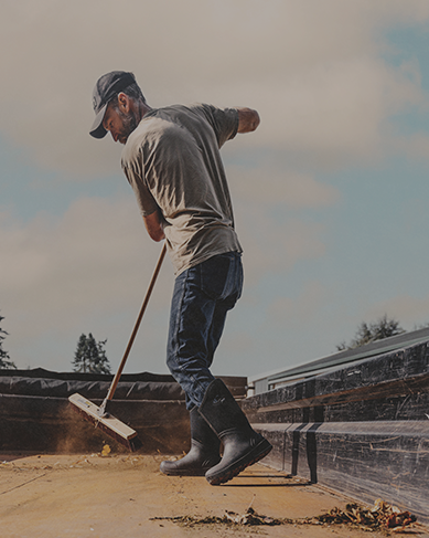 Shop our men's Classic Seamless collection featuring a man sweeping out the bed of a truck.