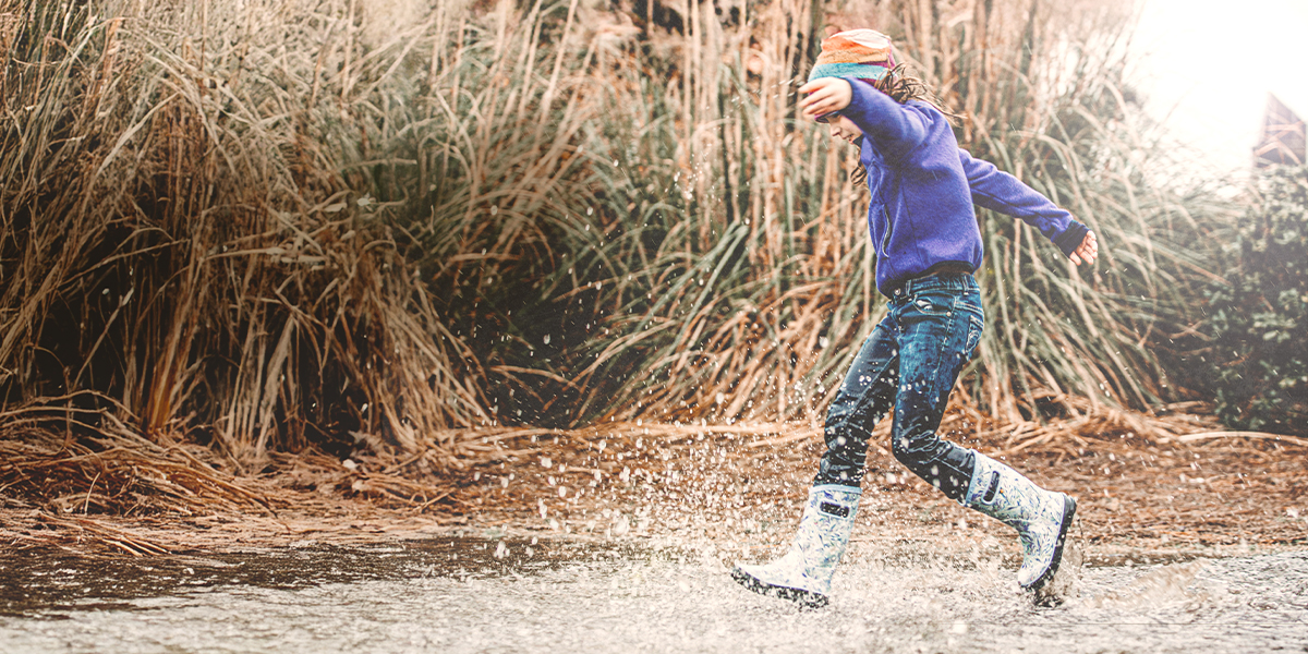 Shop our mid-season sale featuring a girl playing in the rain in rainboots.