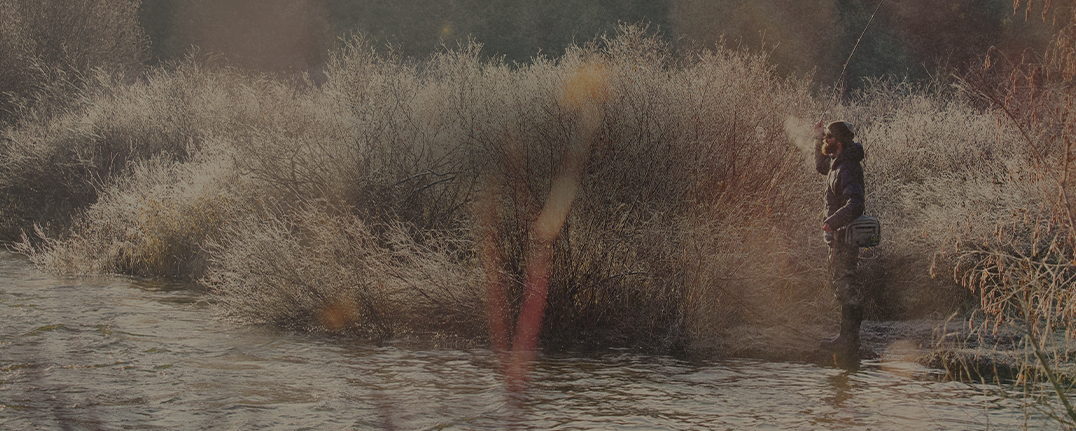 Shop men's camo boots featuring a man fishing on a river.