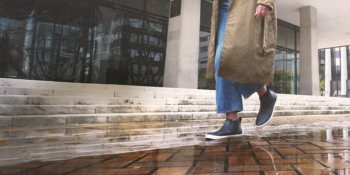 Shop women's fall essentials featuring a woman walking in the rain.