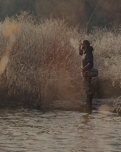 Shop men's camo boots featuring a man fishing on a river.