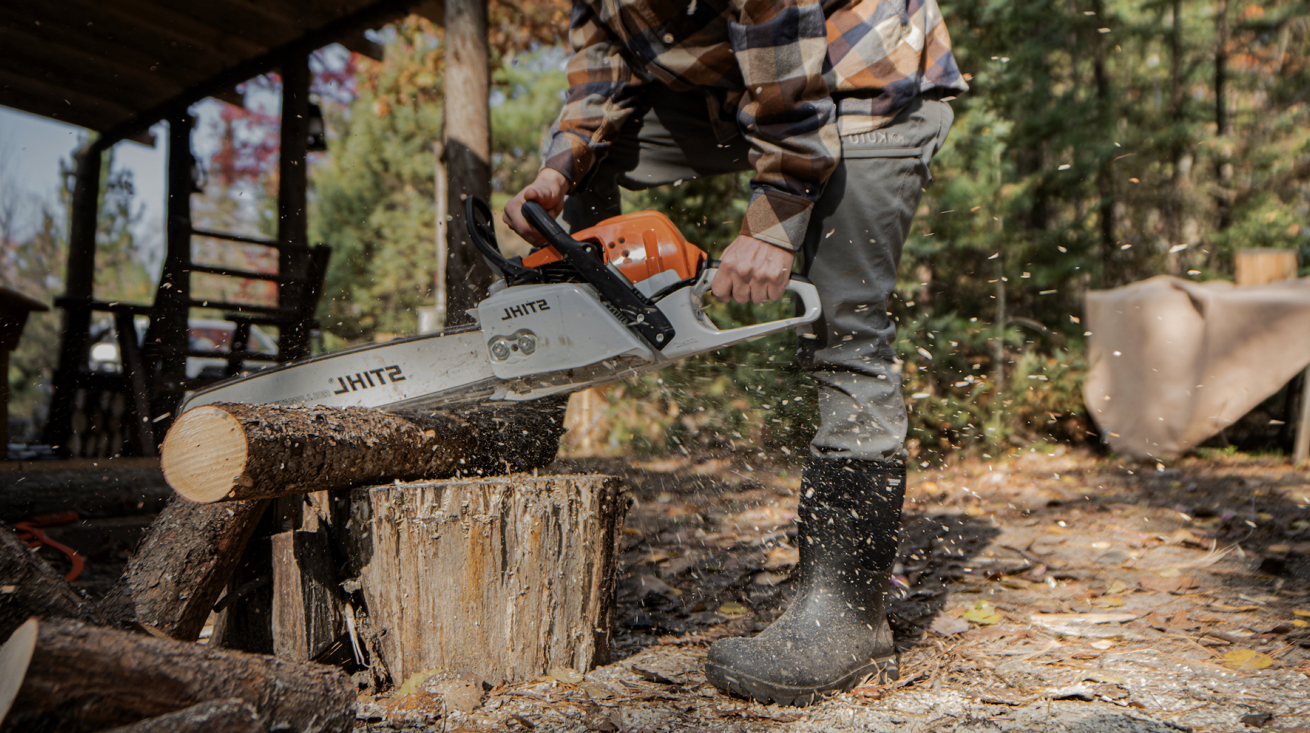 A man chopping wood with a chainsaw wearing the Men’s Classic Seamless mid work boots