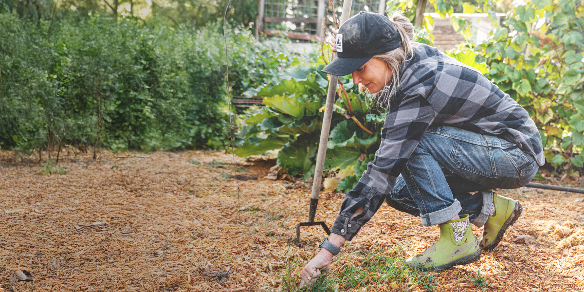Shop women's garden essentials featuring a woman weeding a garden.