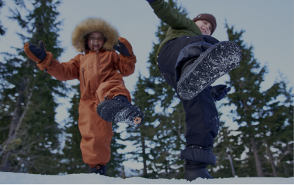 For Kids. Image shows two kids playing in the snow while showing the bottom of their bogs boots to the camera.