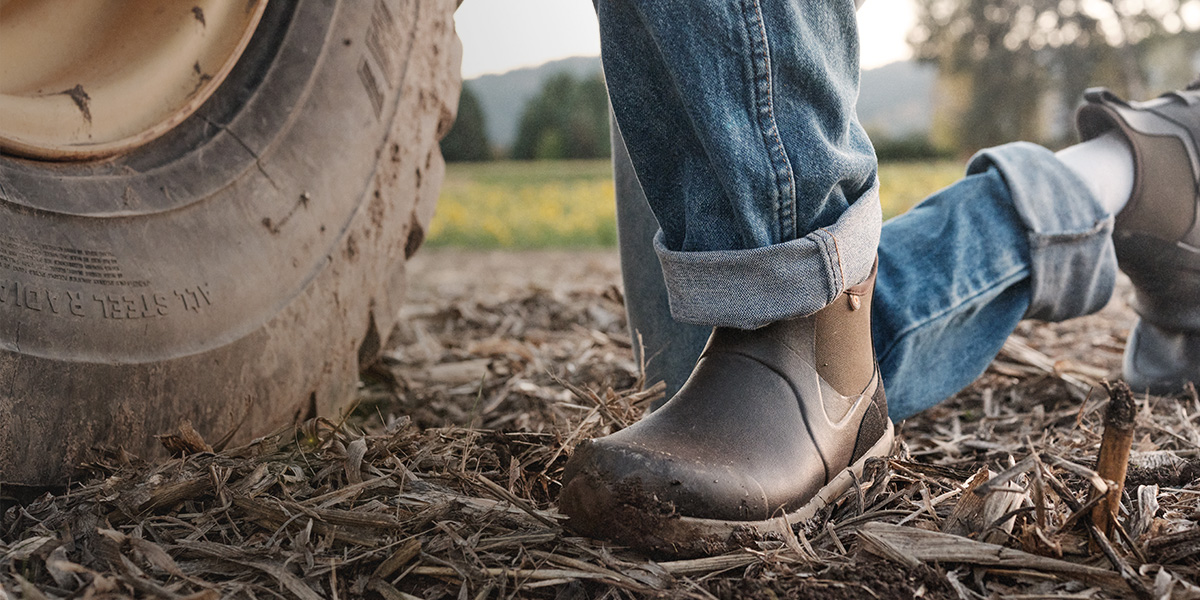 Image features the Spruce Chelsea on a man knelt next to a large tire.