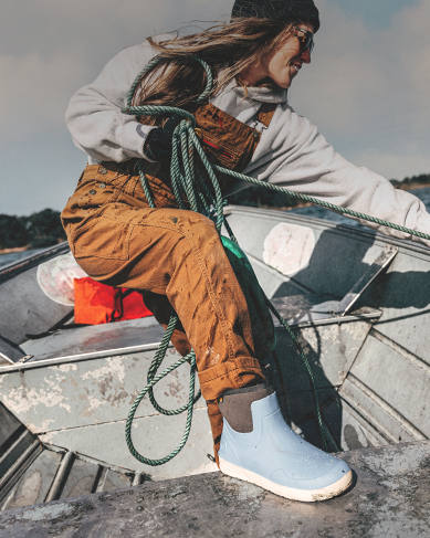 Image features a woman in a fishing boat wearing the Rockaway Seamless Chelsea in blue.