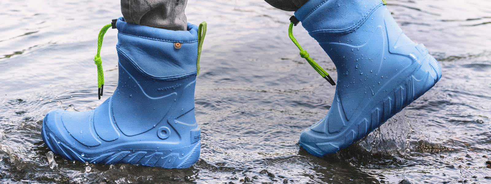 Shop the New Kids' Boga Boot. Image features a close up of a kid wearing their Boga Boots in a blue color while in water.