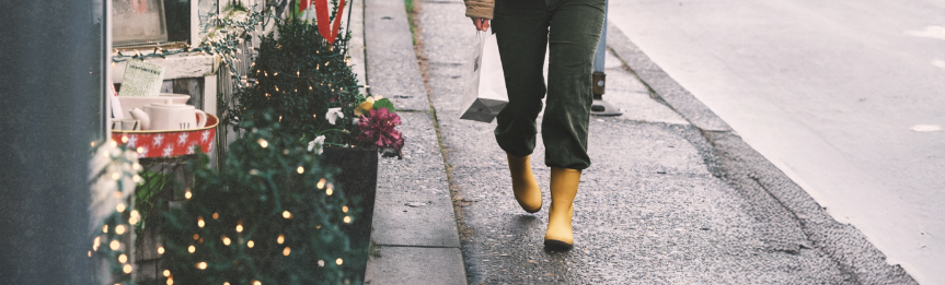 Image features a woman wearing the Amanda II Mid in yellow walking on a wet sidewalk.